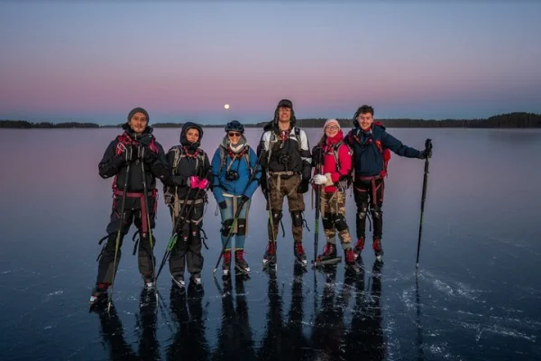 Nordisk skridskoåkning vid solnedgången och fullmånen